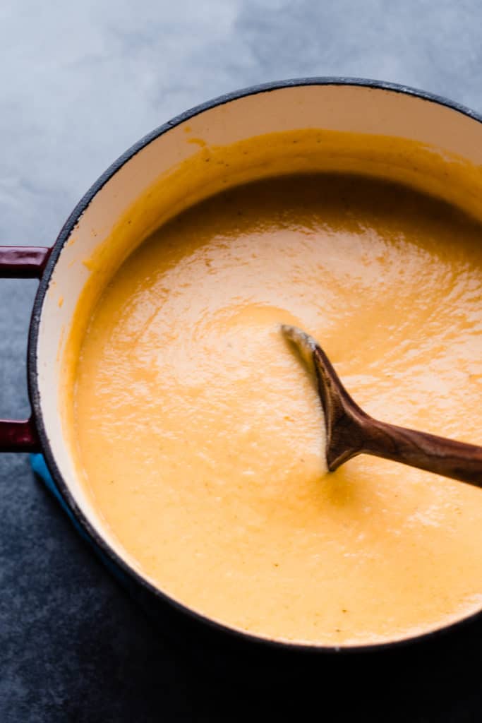 A dutch oven filled with the creamy cheddar cauliflower soup