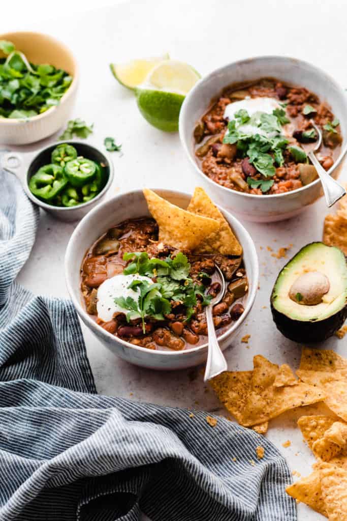 Bowls of chili topped with cilantro and sour cream.