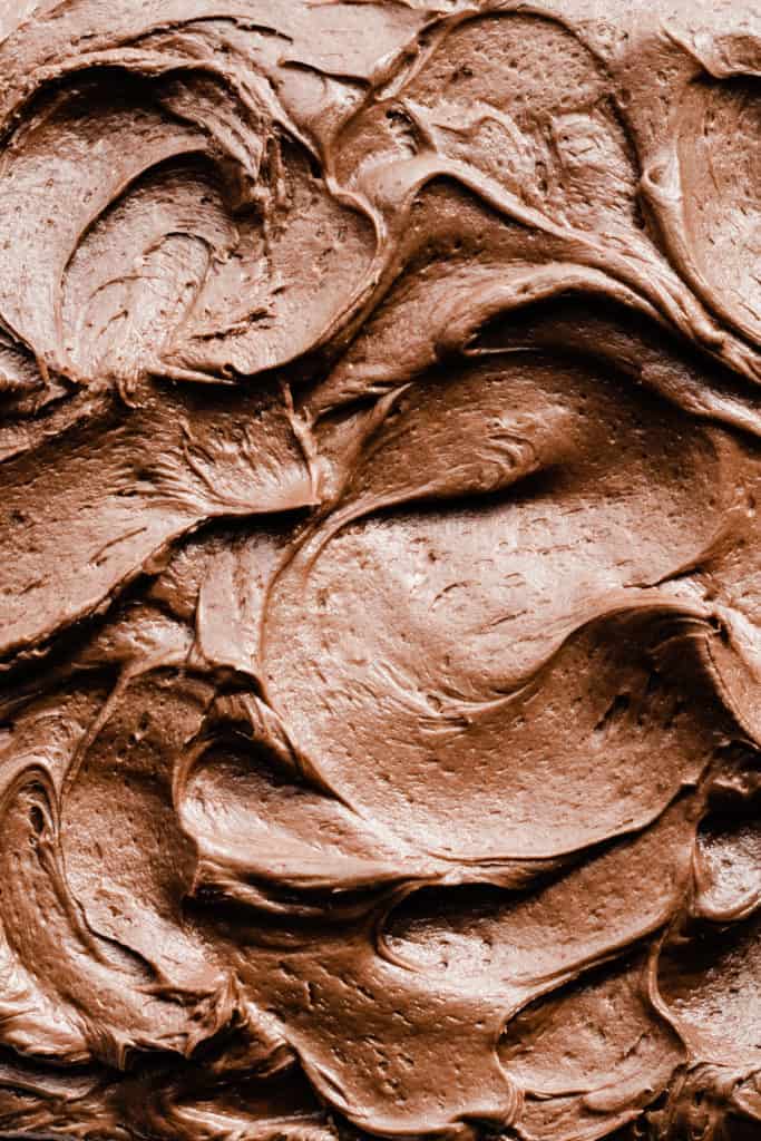 A close-up of swirls of chocolate frosting on the cake