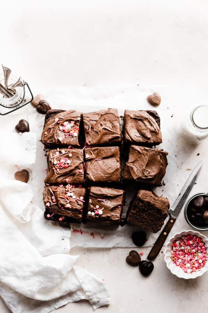 A single-layer square chocolate cake, sliced into squares and frosted with chocolate frosting