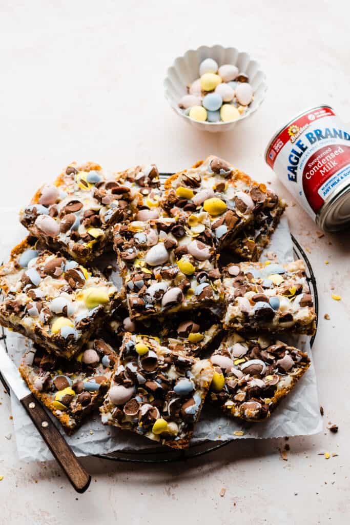 A platter of seven layer bars with easter egg candies sprinkled around