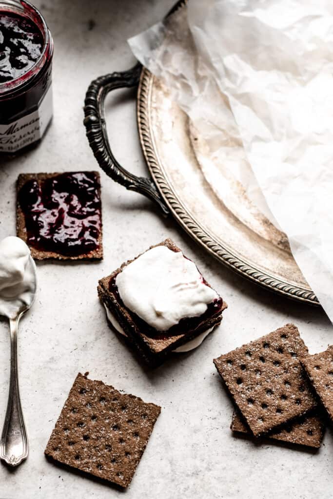 Chocolate graham cracker squares spread with cherry preserves and whipped cream.