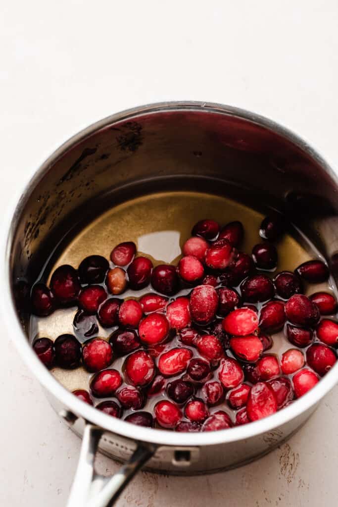 A pot of sugar, water, and frozen cranberries