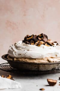 A peanut butter pie piled with whipped cream and peanut butter cups.