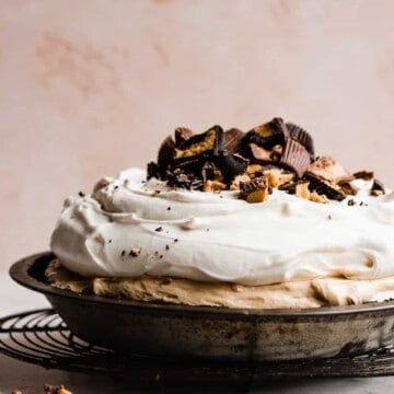 A peanut butter pie piled with whipped cream and peanut butter cups.