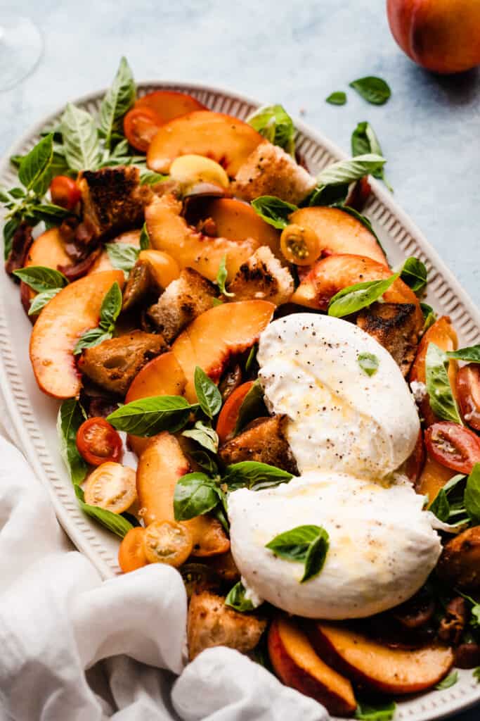 A close-up of the platter of peach panzanella salad. 