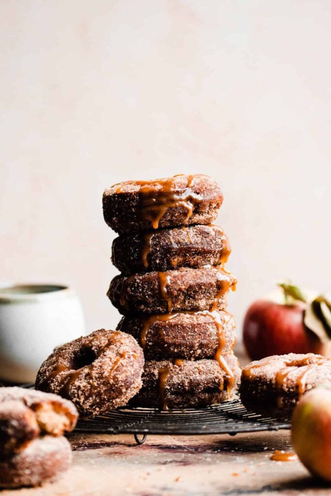 A stack of apple cider donuts drizzled with caramel.