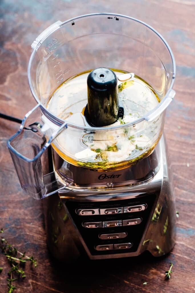An Oster food processor with the dressing ingredients. 