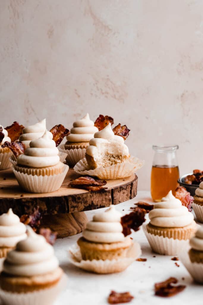 Maple Bacon Cupcakes on a wooden cake stand.