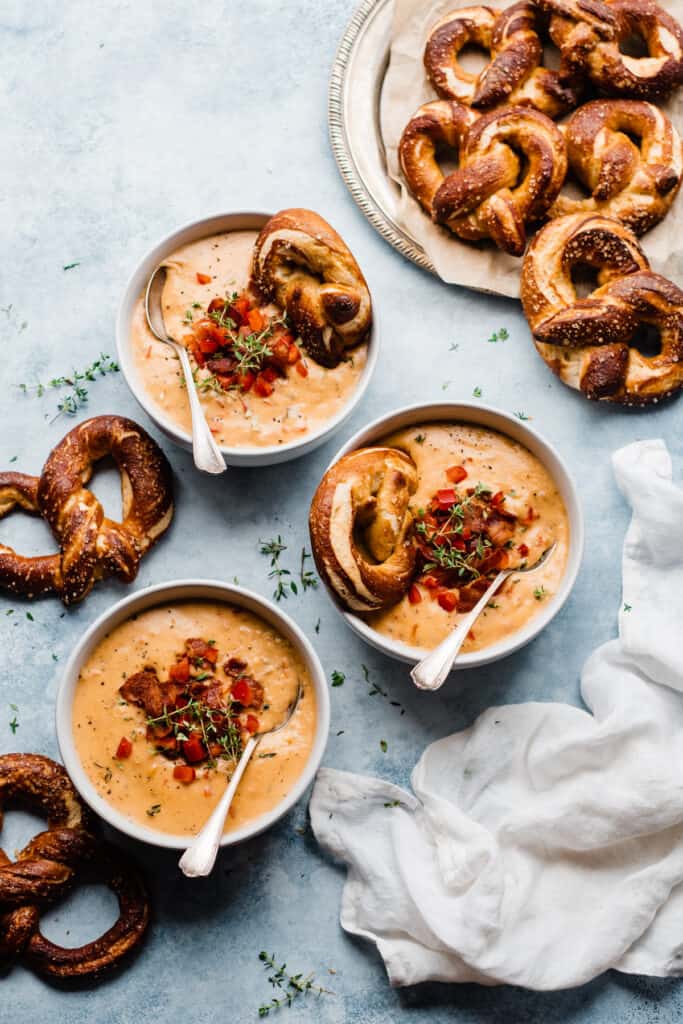 Bowl's of beer cheese soup topped with soft pretzels.