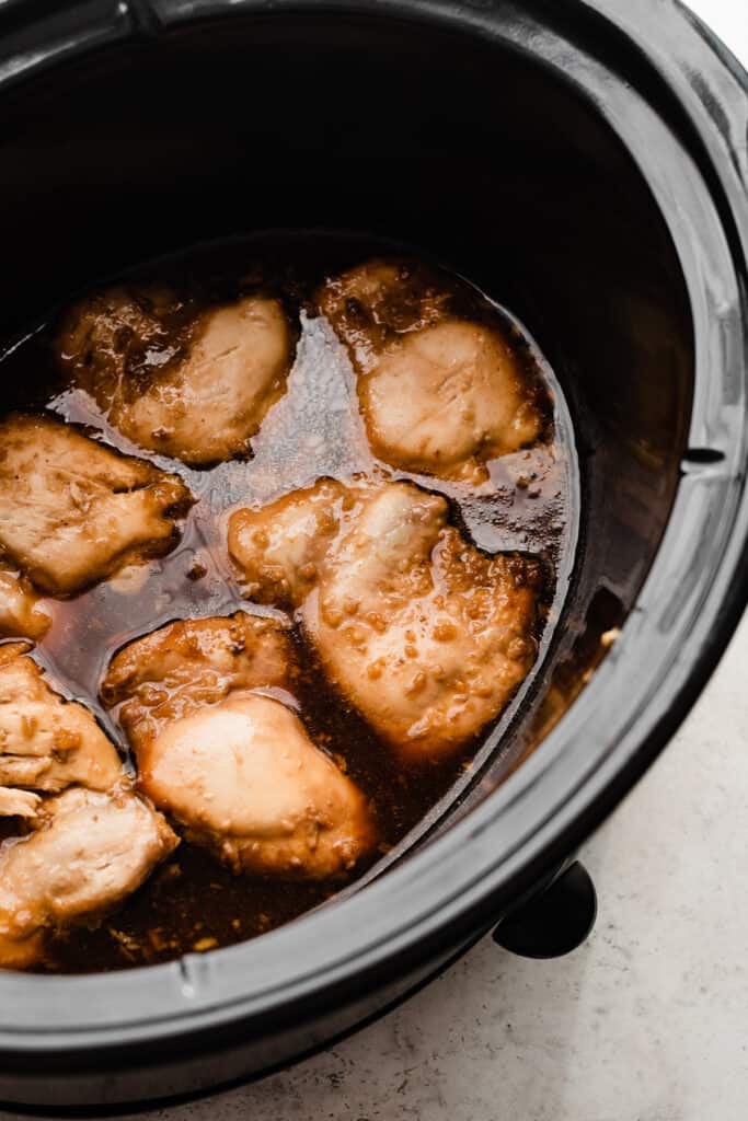 Cooked chicken thighs in honey garlic sauce in the crock pot.