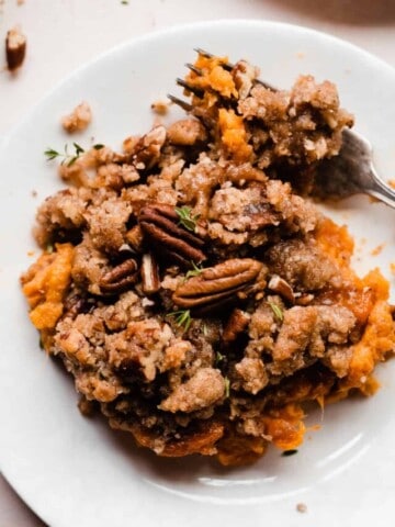 A close up of a plate of sweet potato casserole with brown sugar pecan streusel topping.