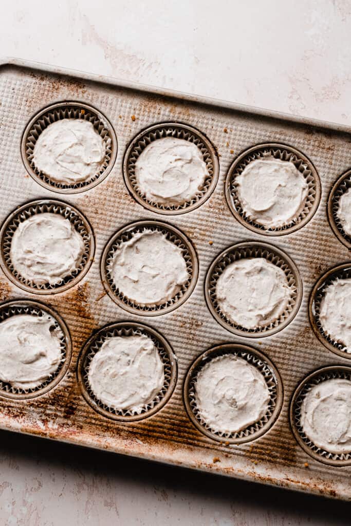 A muffin pan filled with the mini no bake cheesecakes.
