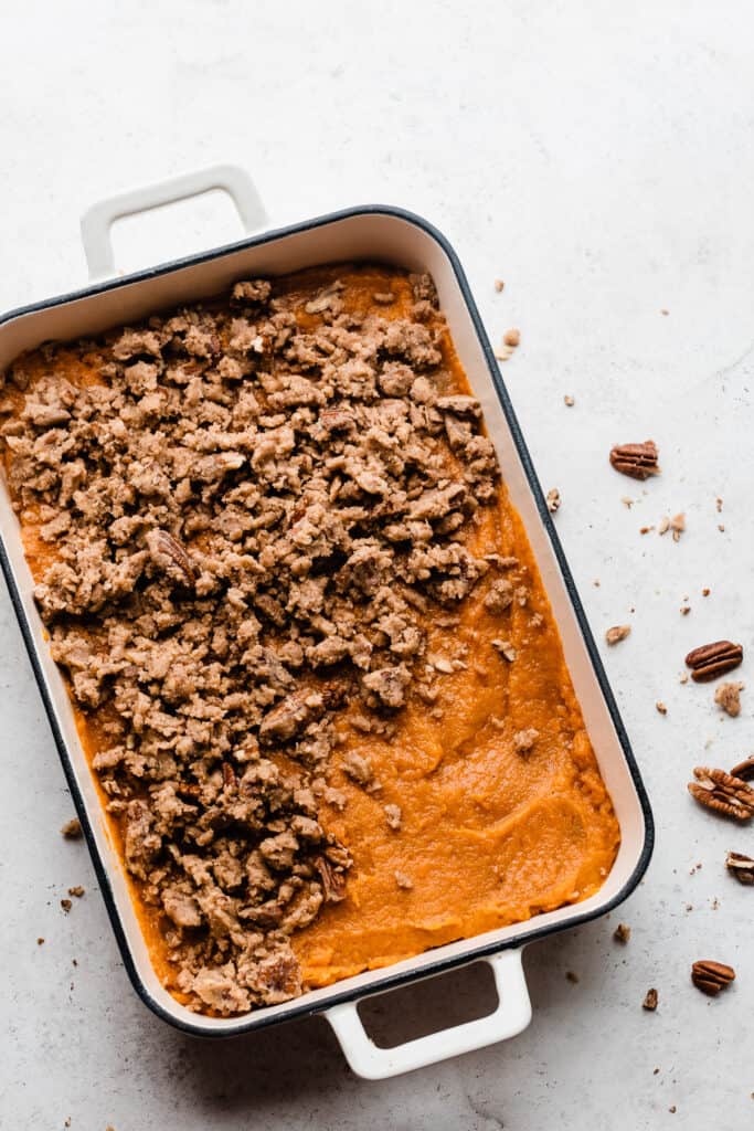 A pan of sweet potato filling with brown sugar pecan streusel crumbled over the top.