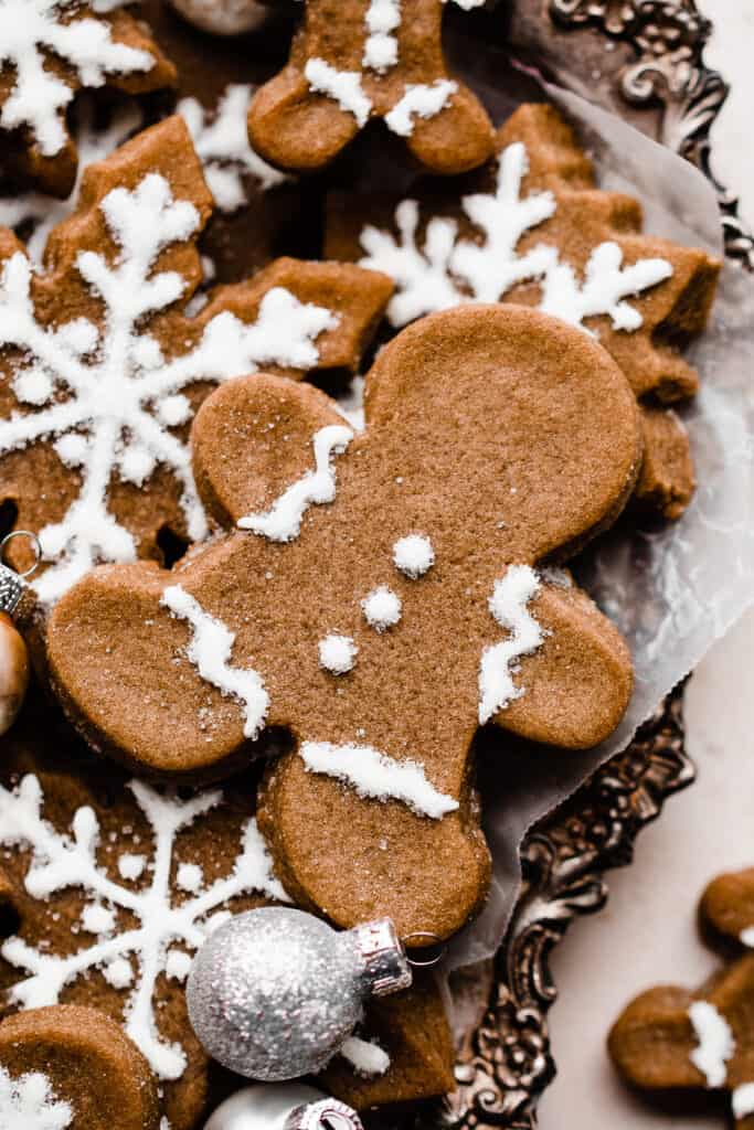 A close-up of a gingerbread man on a pile of cookies.