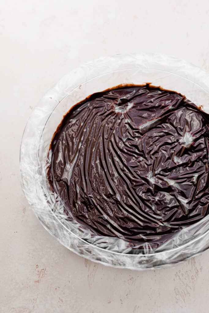 A pie dish filled with the chocolate mixture and covered with plastic wrap.