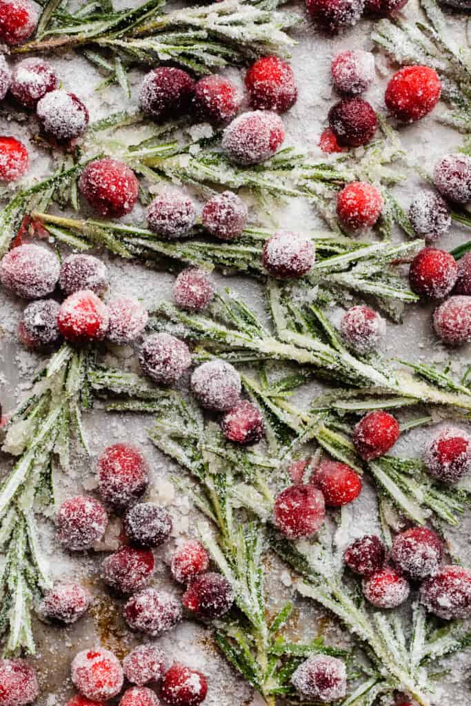 A close-up of sugared cranberries and rosemary, for garnish.