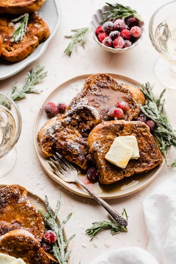 A plate of gingerbread french toast with a bite missing.