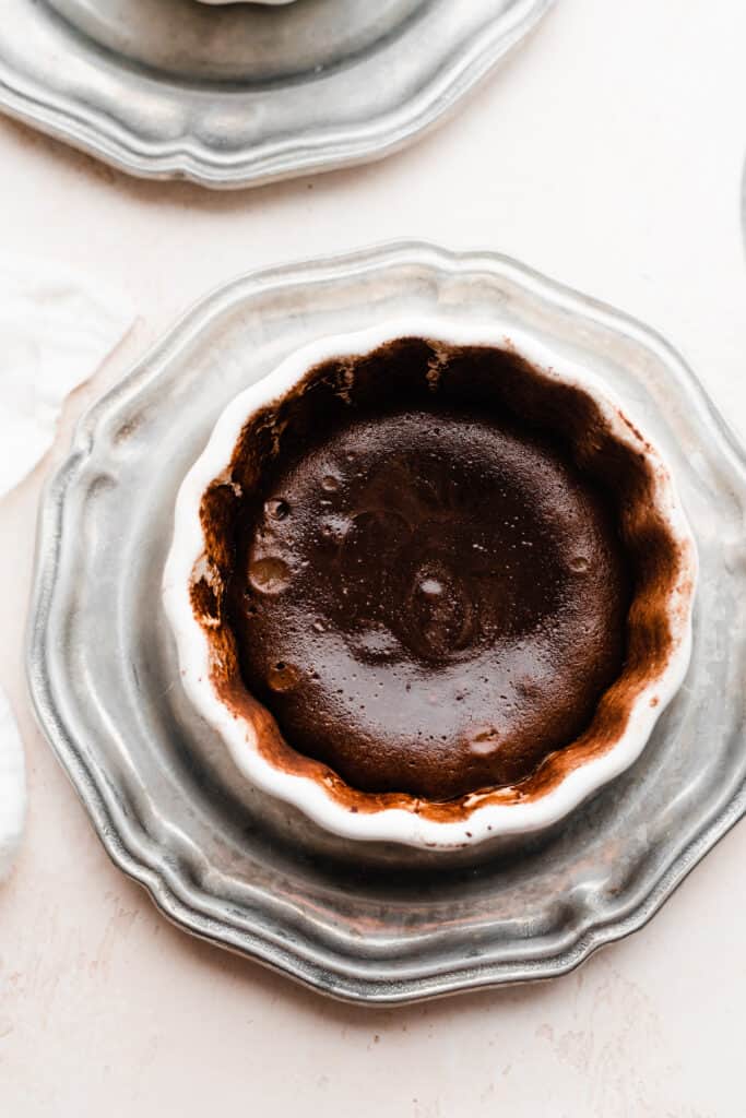 Baked chocolate lava cake in the ramekin, with the slightly shiny center and set edges.