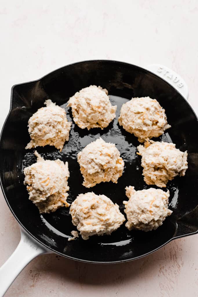 Drop biscuit dough dropped into rounds in a skillet. 
