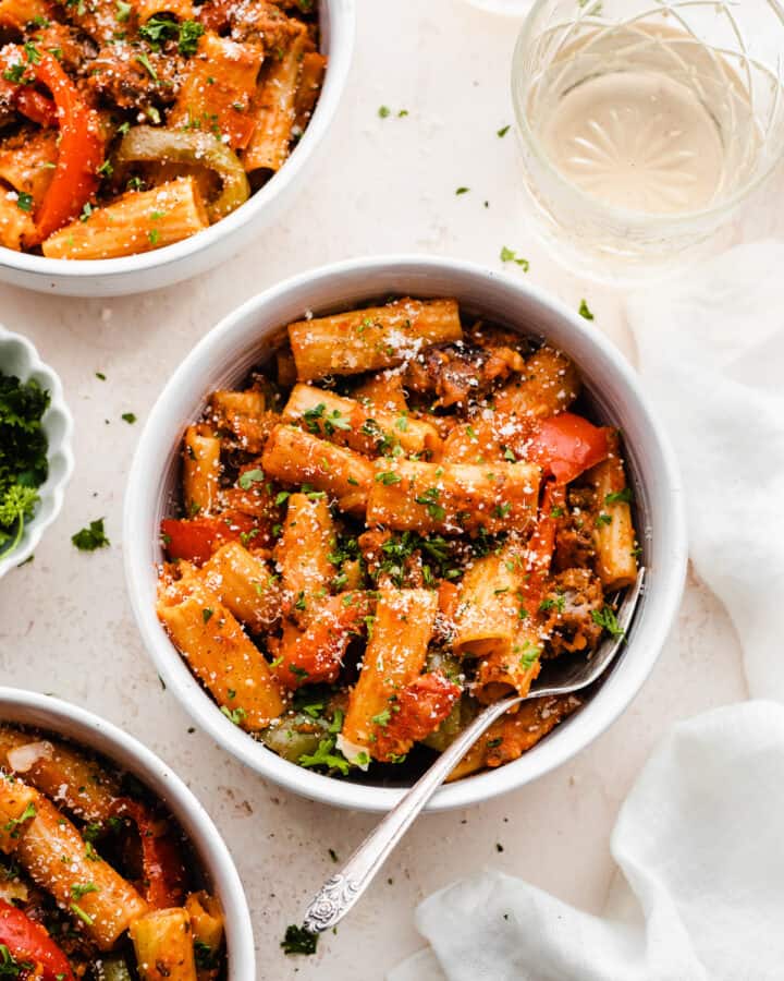 Bowls of the rigatoni pasta topped with parsley and parmesan.