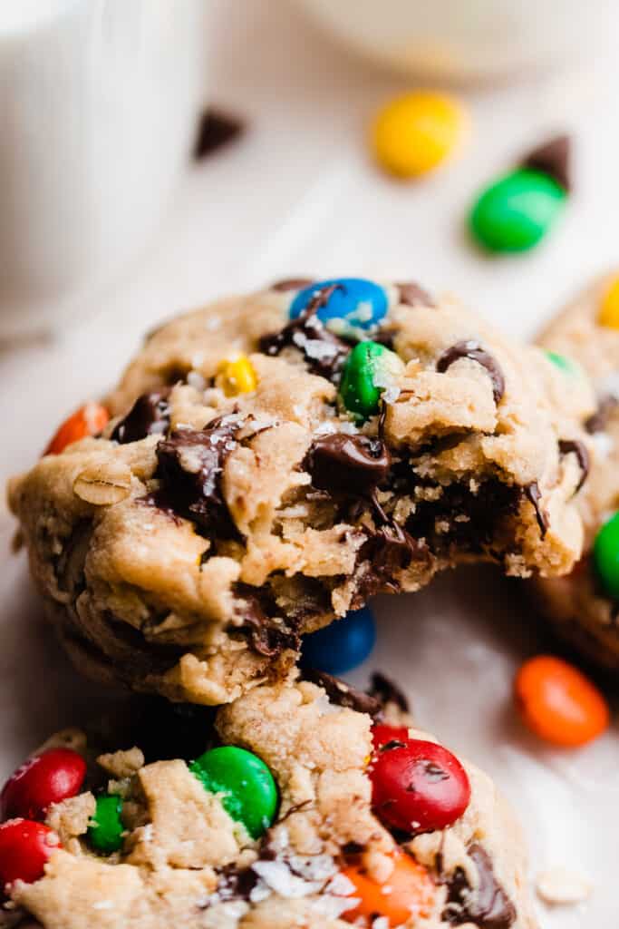 A close-up of a monster cookie with a bite taken out.
