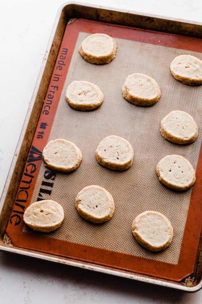 A cookie sheet of baked key lime cookies cooling.