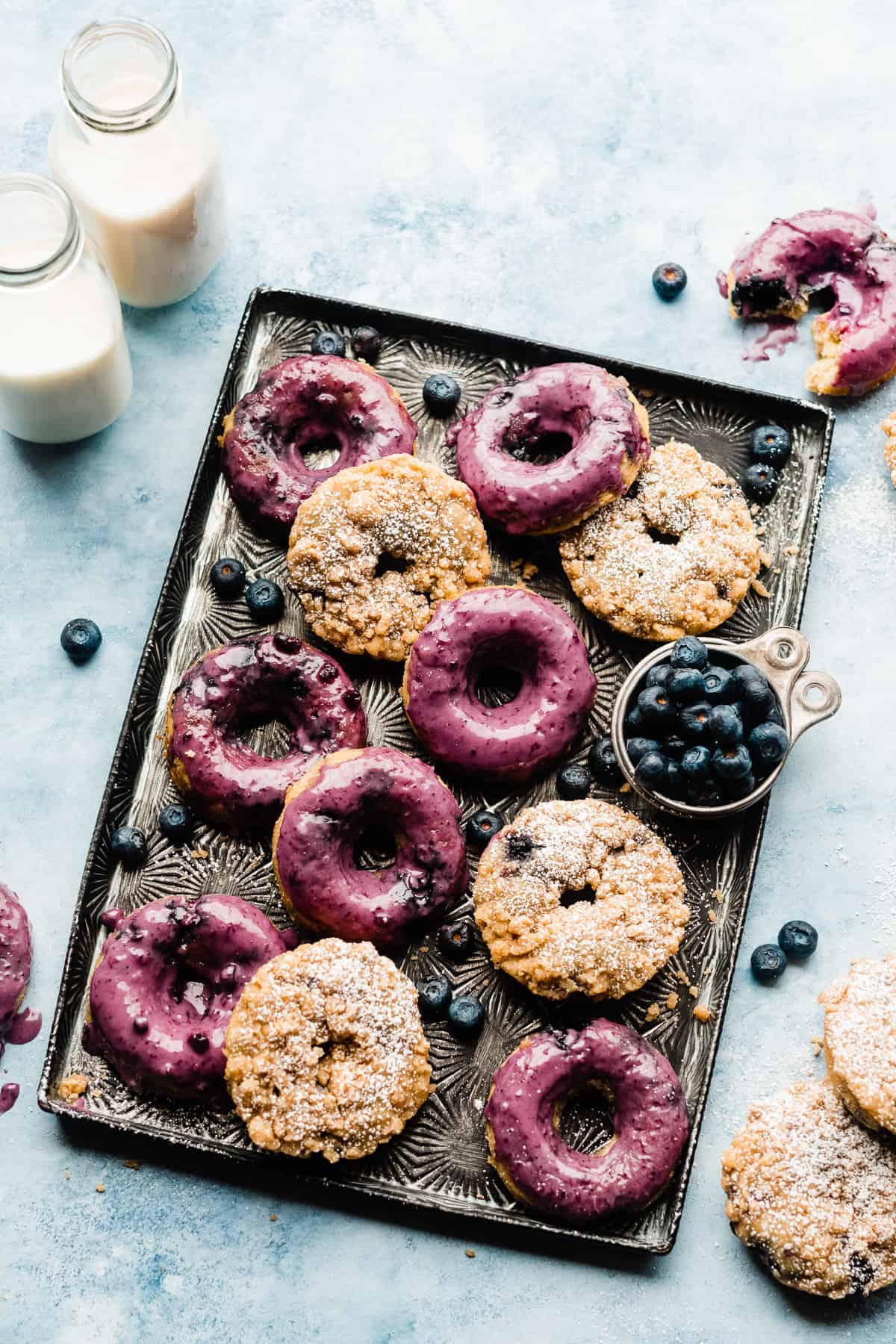 Blueberry donuts on a vintage tray with a blue backdrop.