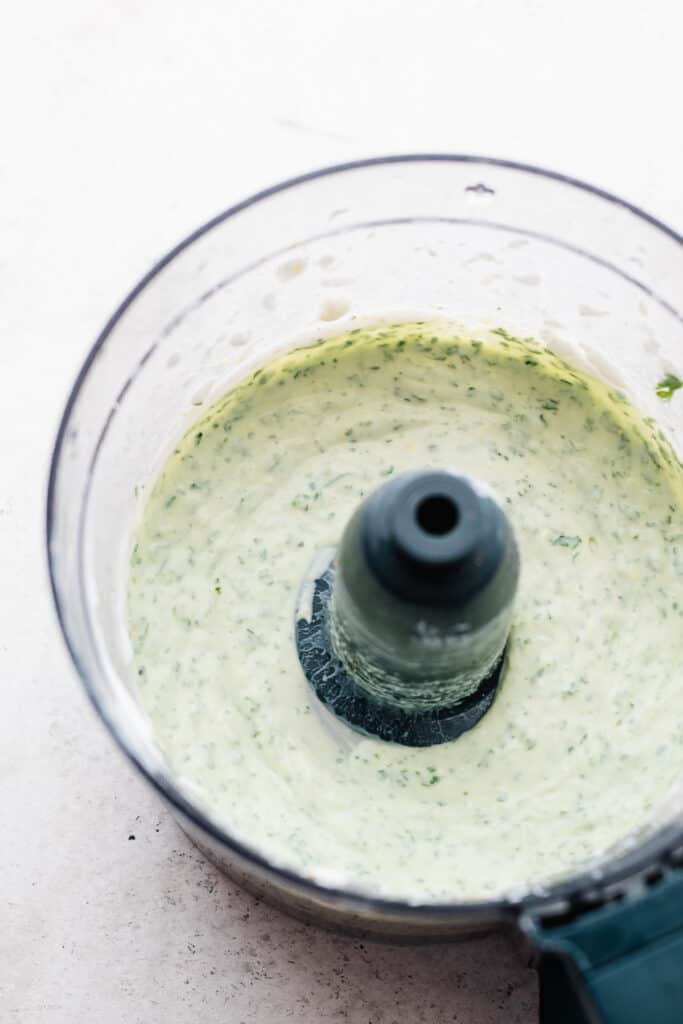 The blended herb yogurt sauce in a food processor.