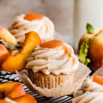 Peach cupcakes topped with frosting and peach filling.