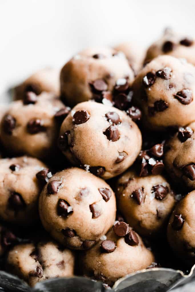 A close-up of the cookie dough balls sprinkled with extra chocolate chips and flaky sea salt. 