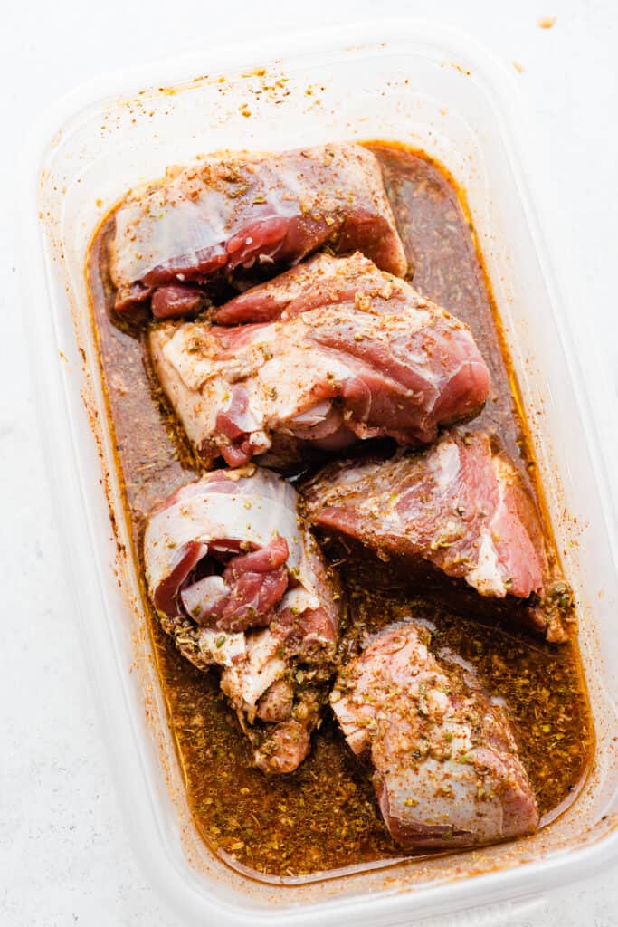 A tupperware with the lamb marinating. 