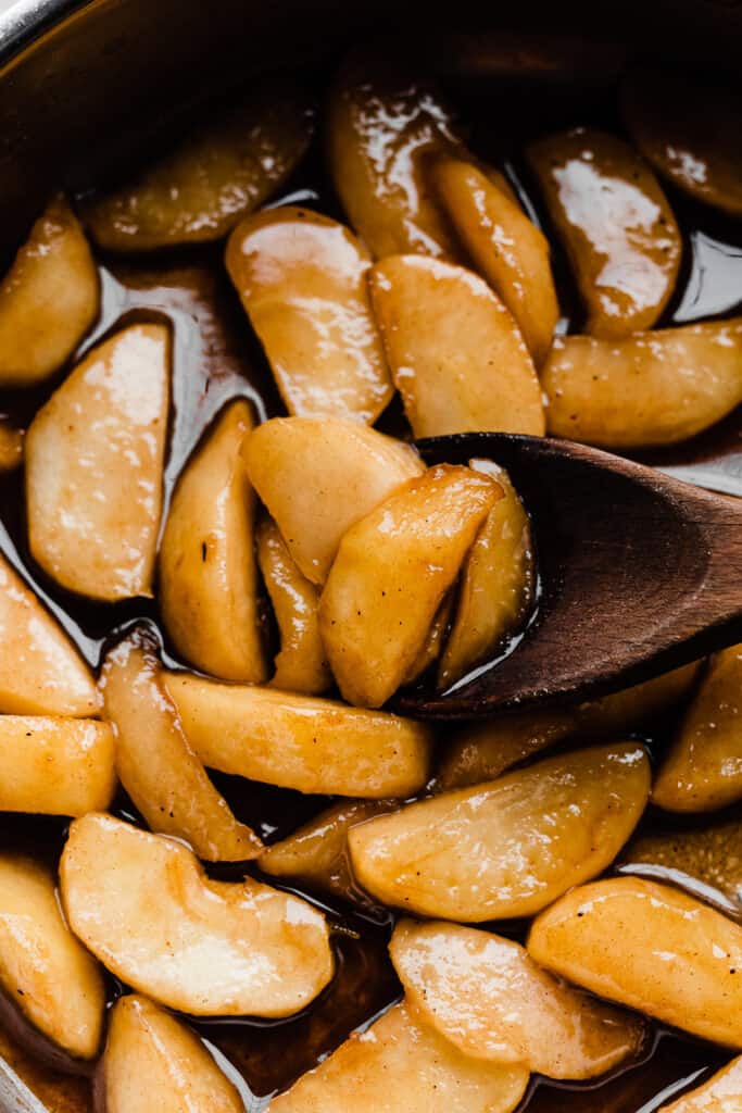 A close-up of caramelized apple slices in a pan.