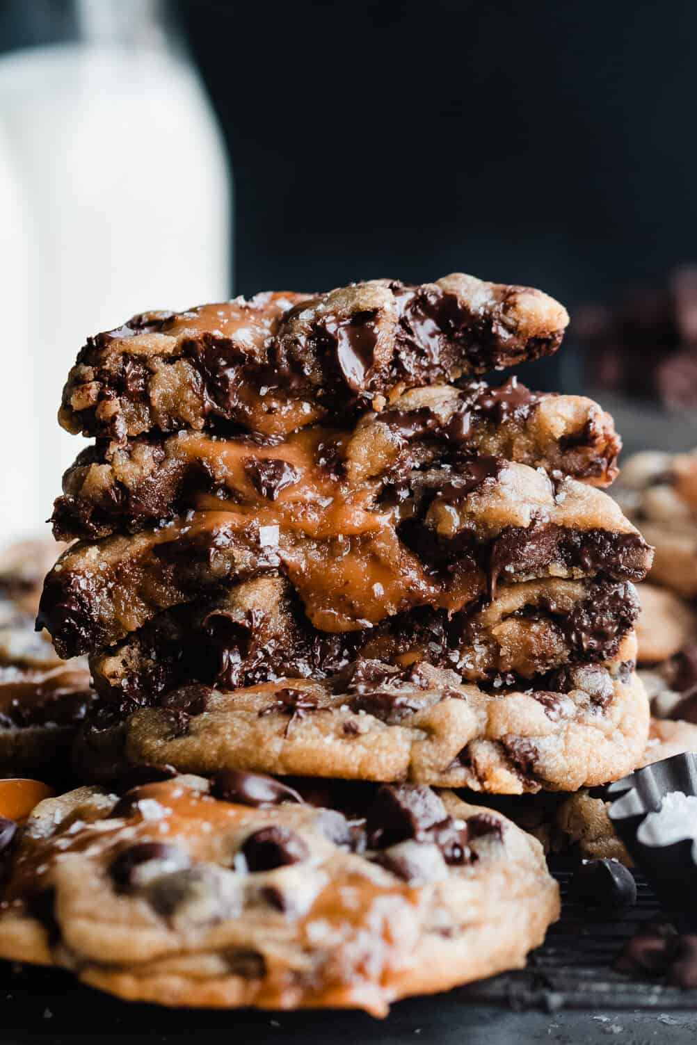A stack of broken open cookies with melty caramel and chocolate running out.