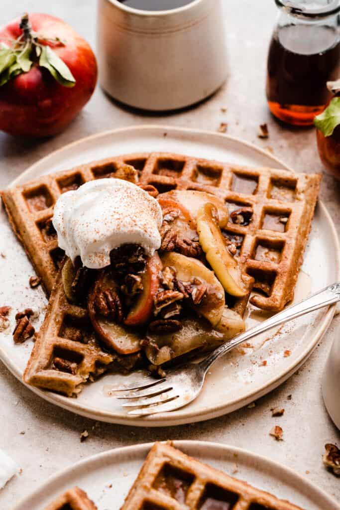 A close-up of a plate of the waffles with a fork taking a bite out.