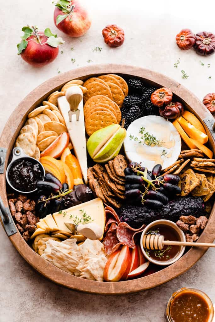 A bird's eye view of the cheese board, showing honey, figs, crackers, and goat cheese.
