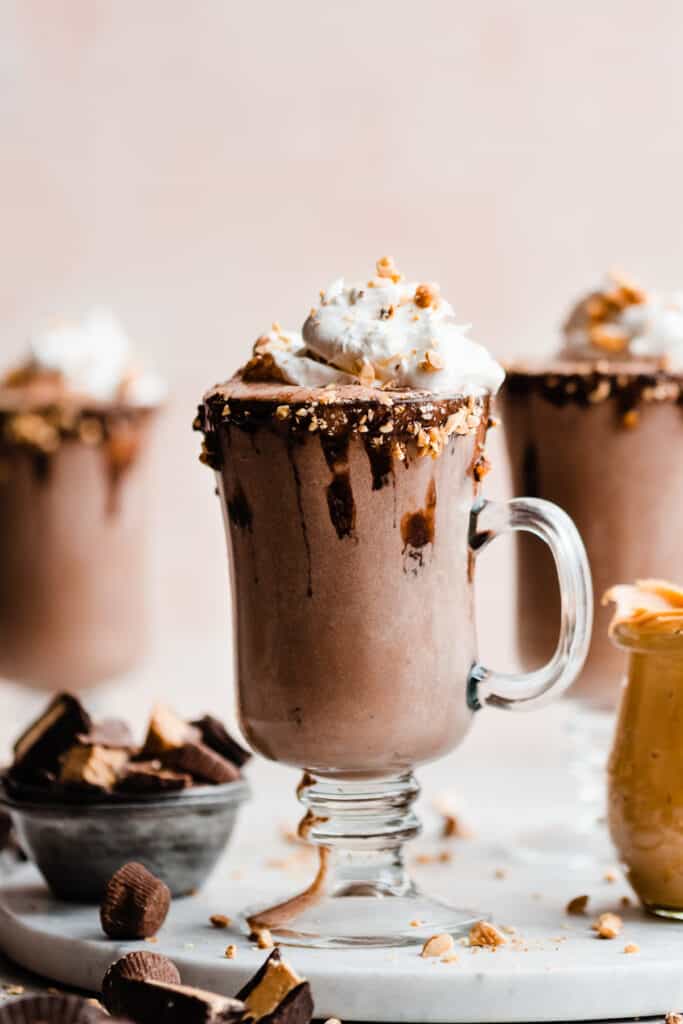 Milkshakes with chocolate dipped rims and whipped cream on top.
