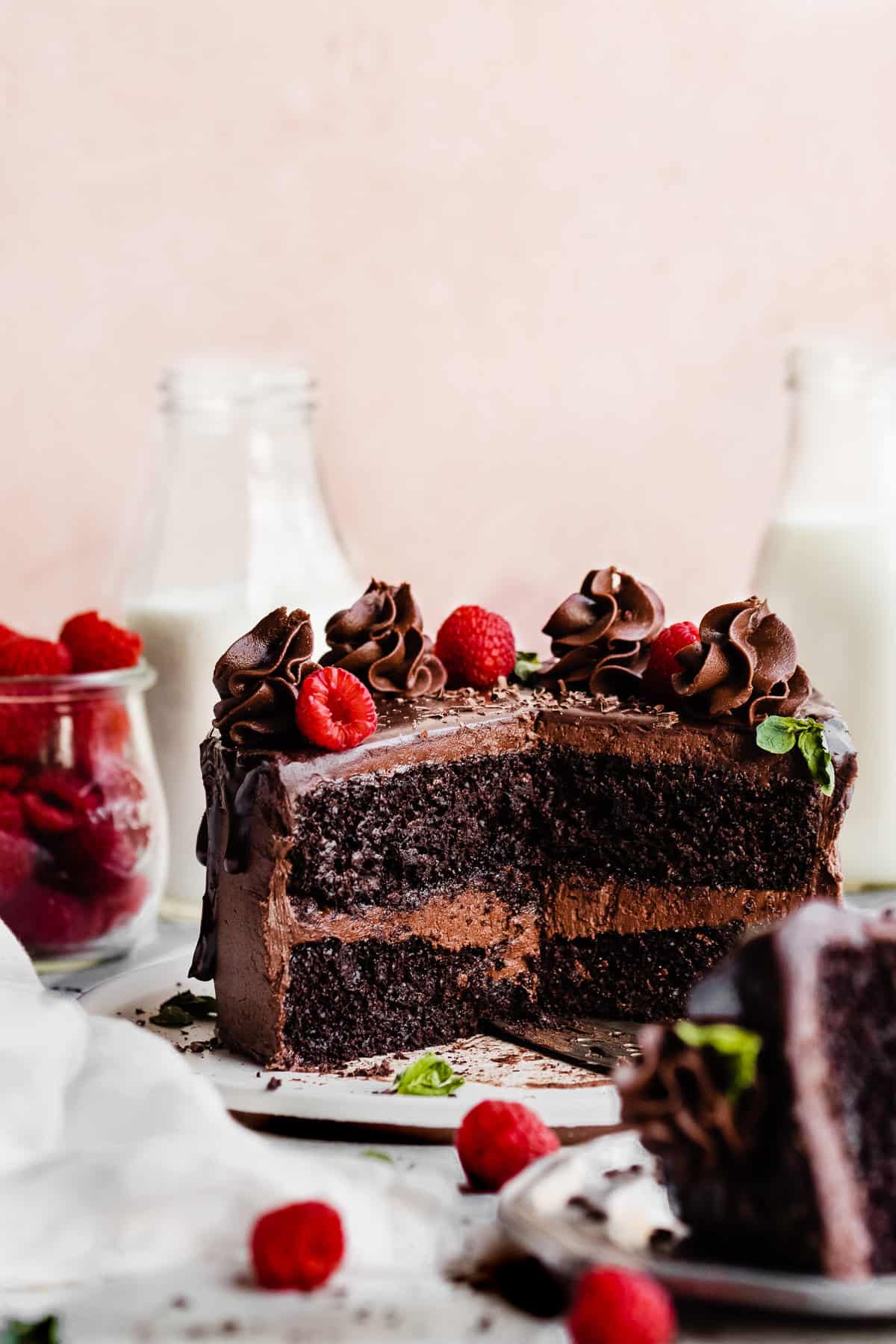 The sliced open cake, revealing the fudgy insides, with raspberries and chocolate frosting swirls on top.