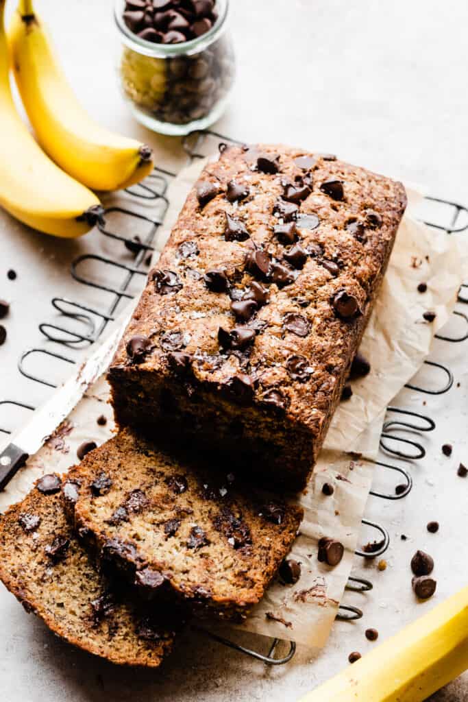 Sliced loaf of banana bread with melty chocolate chips.