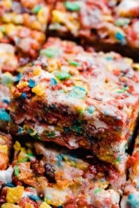 A close-up of a fruity pebble treat with cereal glaze.