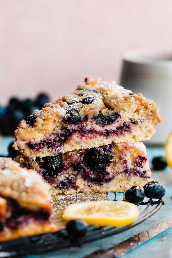 Pieces of blueberry coffee cake stacked on a wire rack.