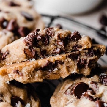 Two halves of an eggless chocolate chip cookie, showing their gooey insides and melty chocolate chips.