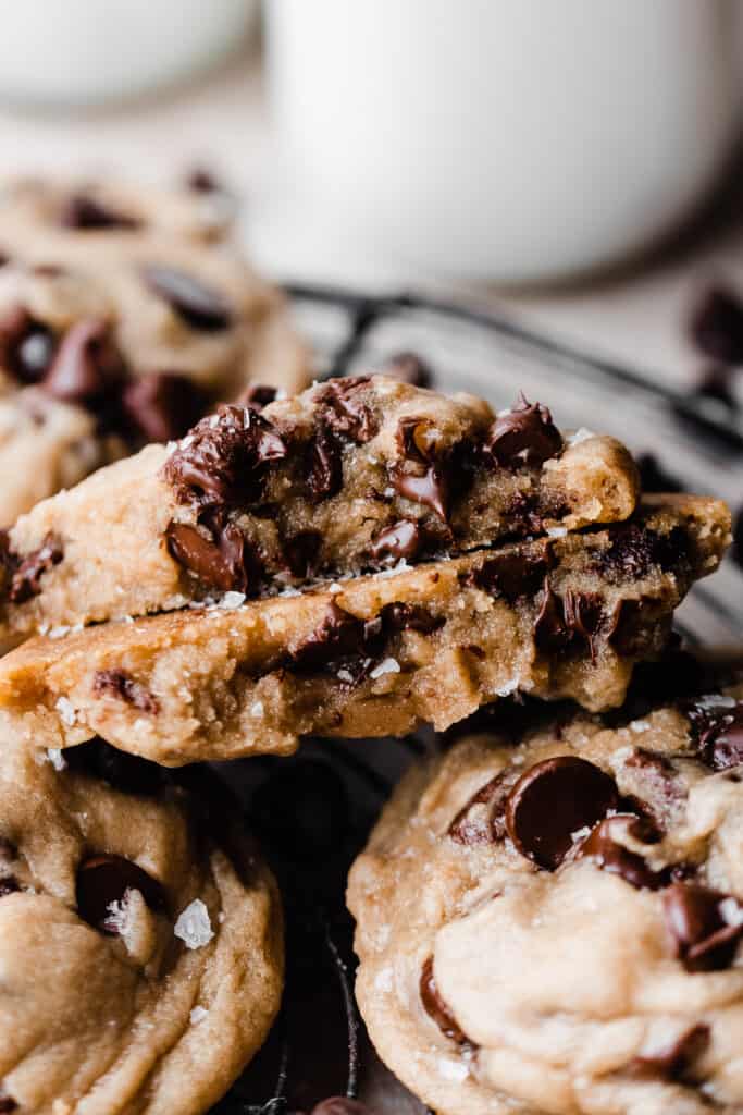 Two halves of a broken open cookie, showing their gooey insides and melty chocolate chips.