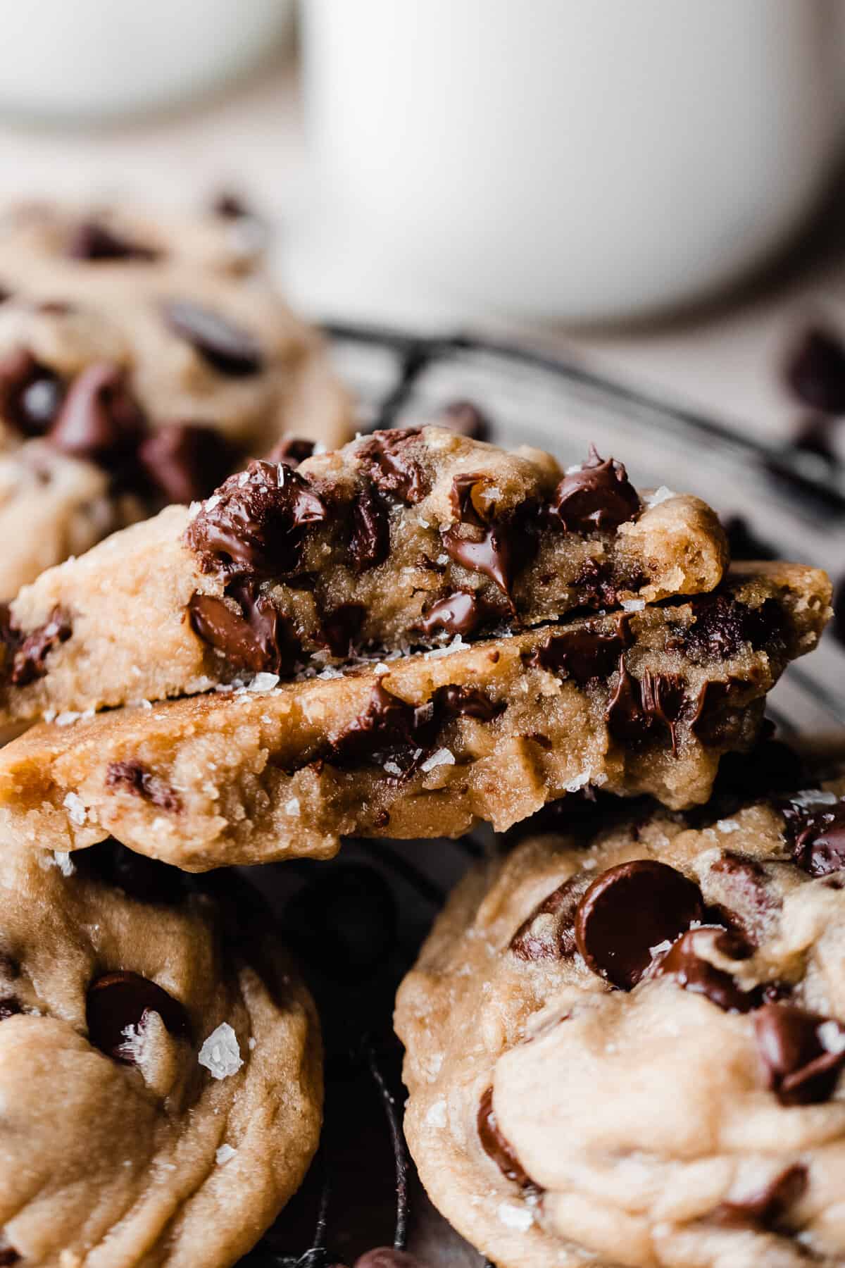 Two halves of an eggless chocolate chip cookie, showing their gooey insides and melty chocolate chips.