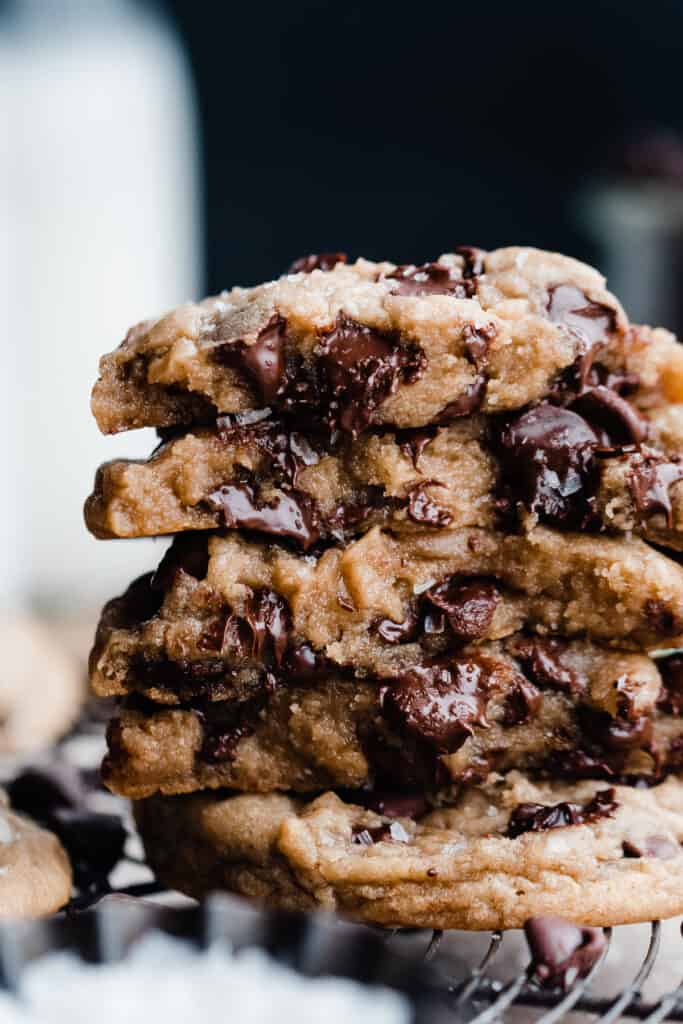A close-up on the stack of chocolate chip cookies with their gooey insides showing.