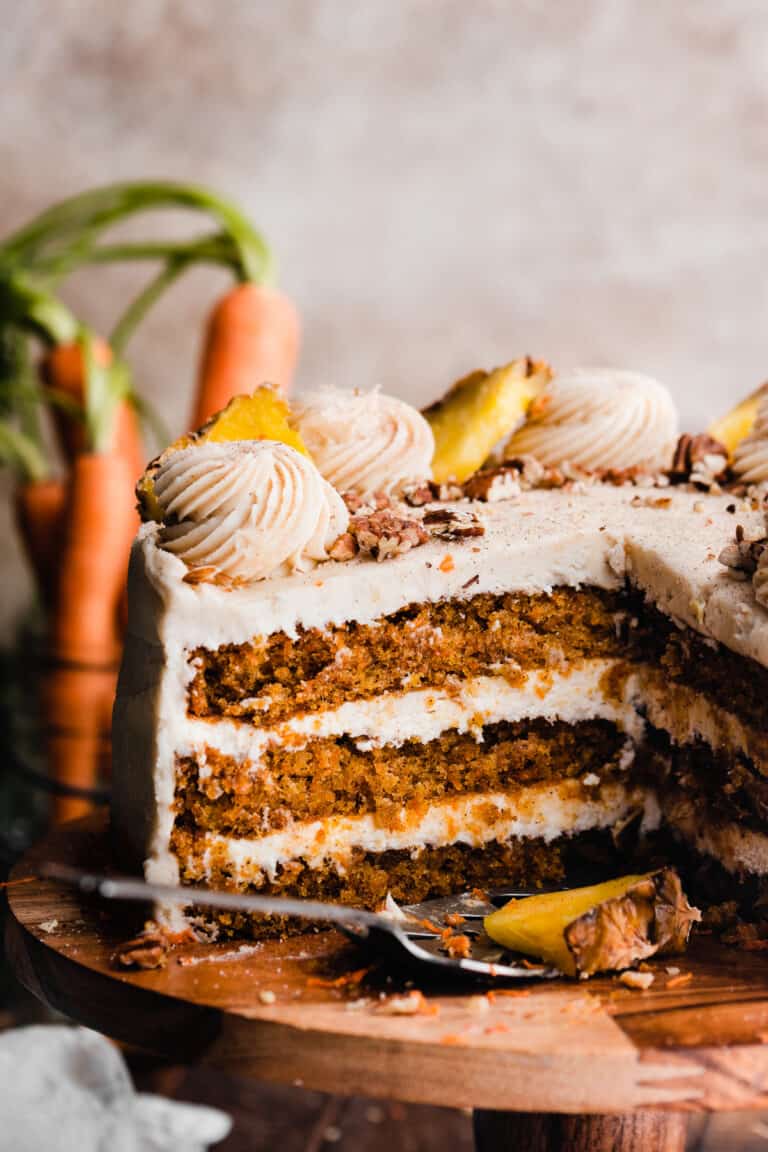 The sliced open Pineapple Carrot Cake with visible fluffy cake layers and cream cheese frosting swirls on top.