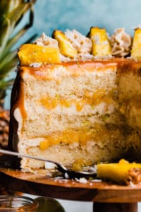A close-up on the sliced pina colada cake, with coconut frosting and pineapple filling showing.