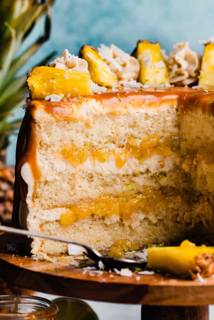 A close-up on the inside of the pina colada cake, with layers of cake, frosting, and pineapple filling visible.