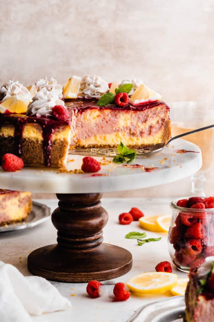 The sliced cheesecake on a cake stand.