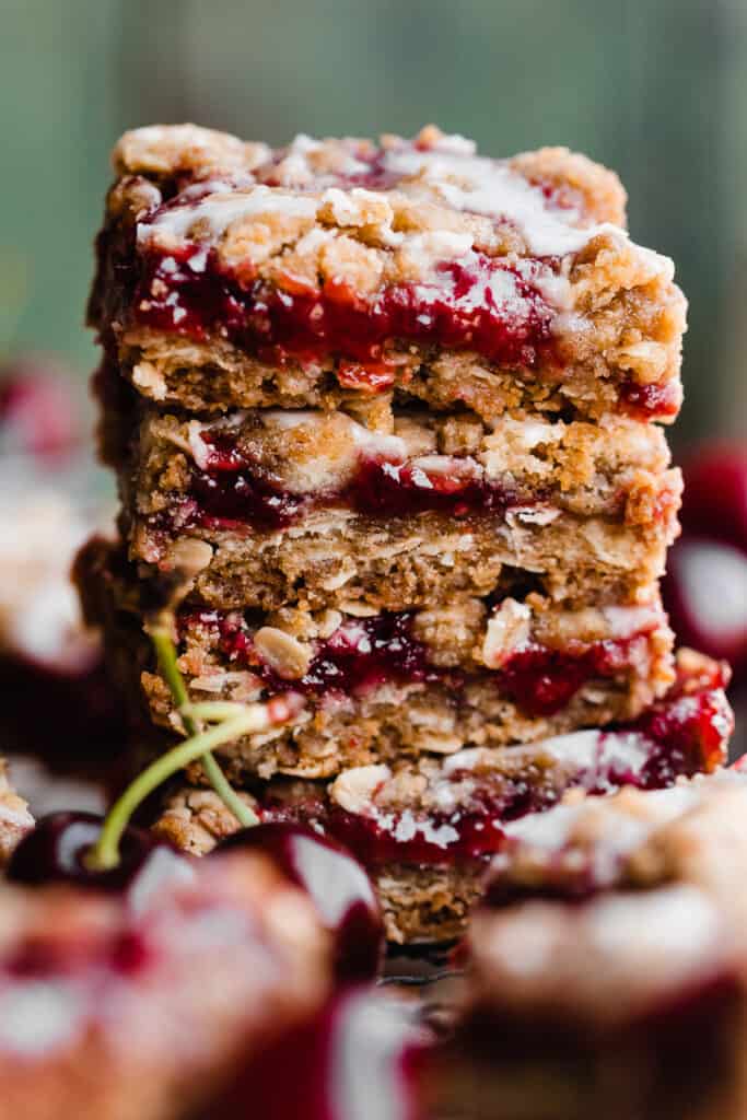 A stack of cherry pie bars with almond glaze.